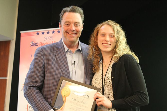 Man presenting award to young woman