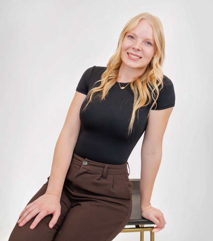 Woman in black tee sitting on stool