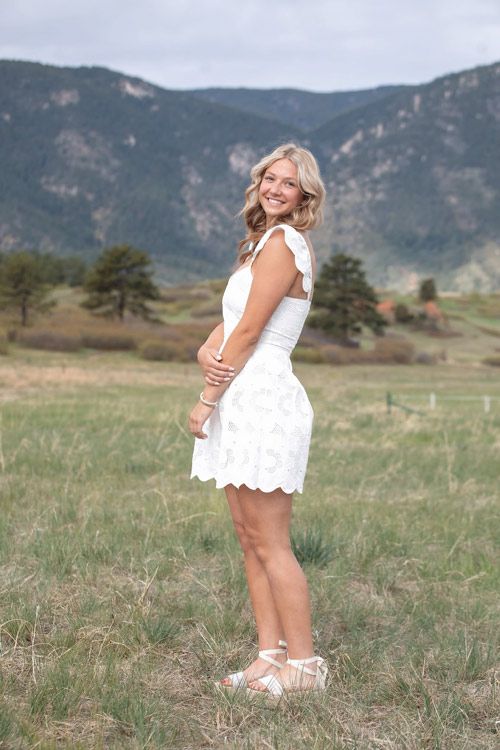 Woman in white dress in front of mountains