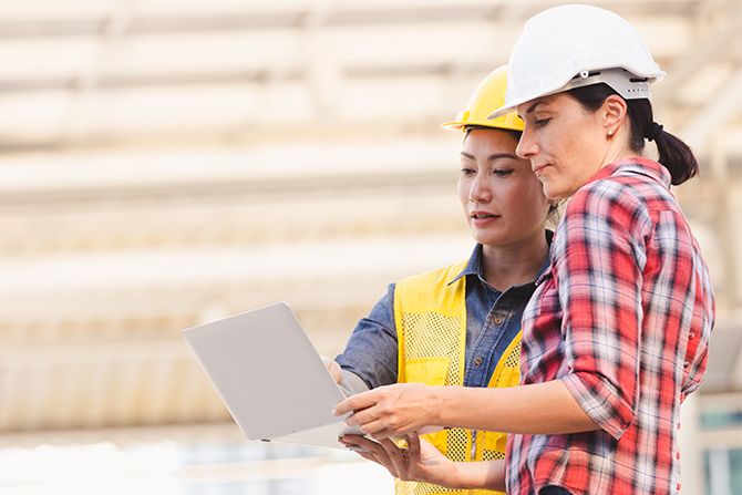 Two female construction workers looking at tablet